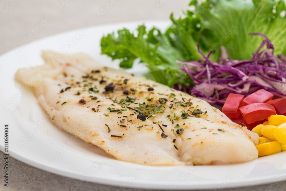 Grilled fish fillet steak with herb and vegetables on plate Grilled fish fillet steak with herb and vegetables on plate