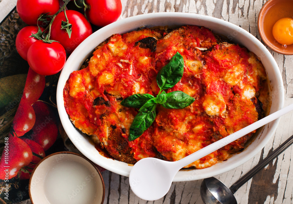 Ταπετσαρία delicious parmigiana with raw ingredients on the table