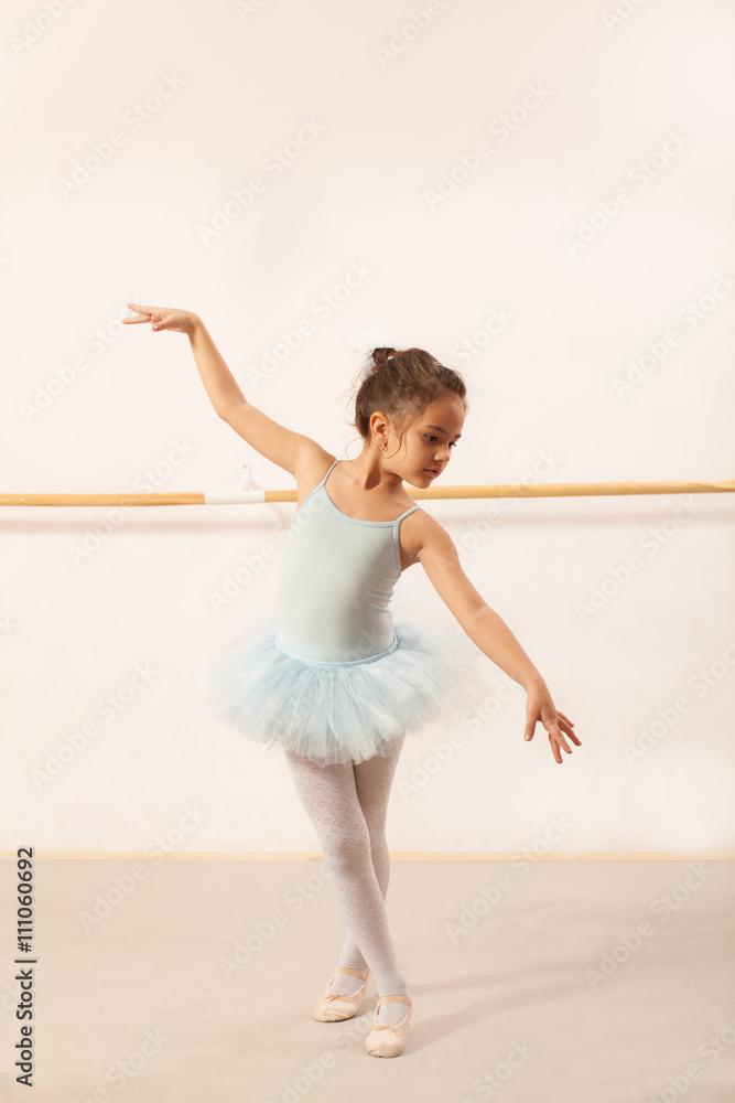 Little ballerina girl dancing in ballet studio
