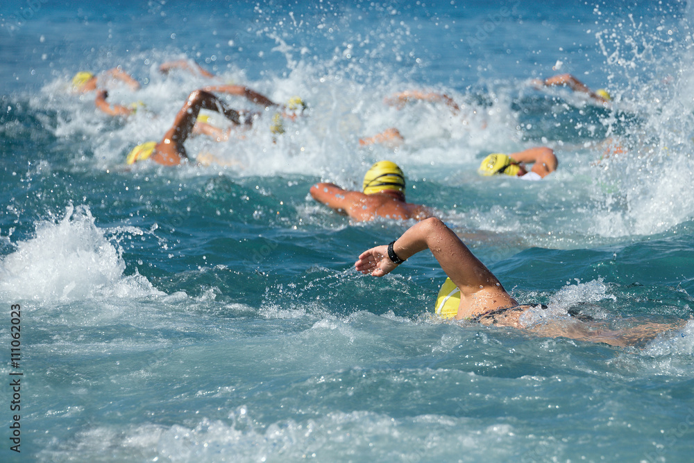  Swimming athletes in a triathlon contest