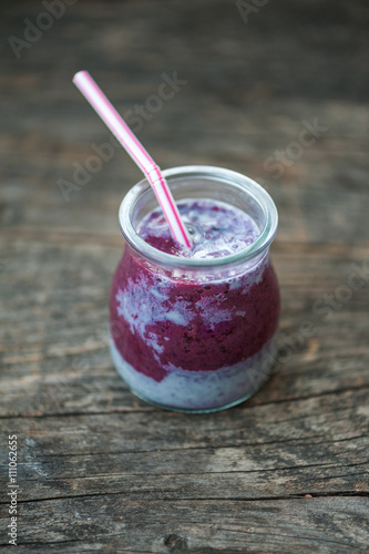 Blueberry smoothie in small glasses on a wooden table
