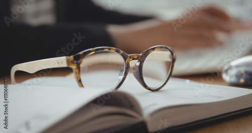 Close up of glasses is putting on a book photo
