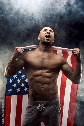 Handsome bald topless man with American flag on shoulders photo