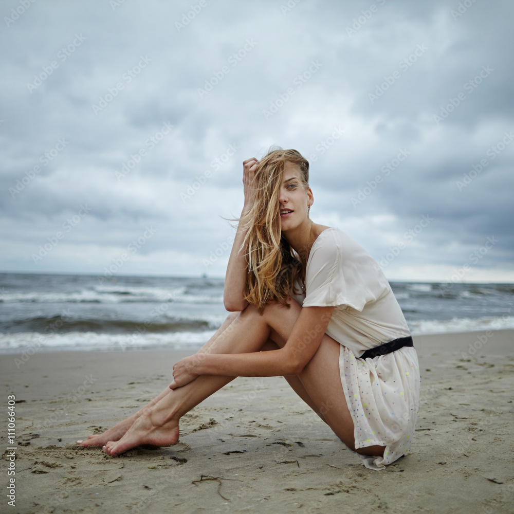 young beautiful woman on cold windy beach young beautiful woman on cold windy beach