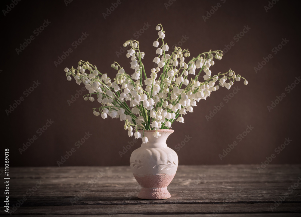 Lilly of valley in vase on wooden table Lilly of valley in vase on wooden table