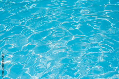 Blue water in swimming pool and water surface with sun reflection