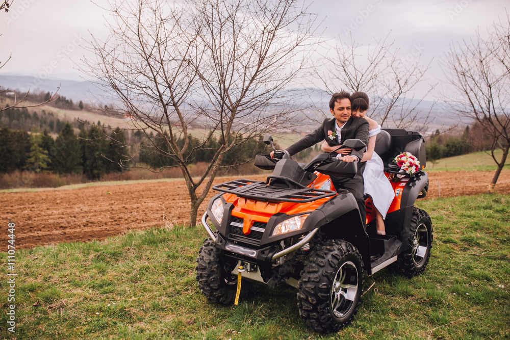 Man and woman having fun on an off road adventure. Couple riding on a quad bike in countryside on a summer day. Man and woman having fun on an off road adventure. Couple riding on a quad bike in countryside on a summer day.