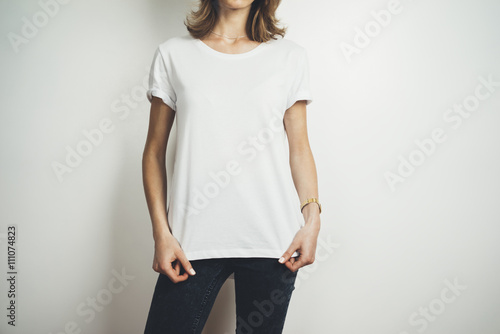 Cropped image of young hipster girl wearing blank white t-shirt and black jeans, mock-up of balnk white t-shirt, white background