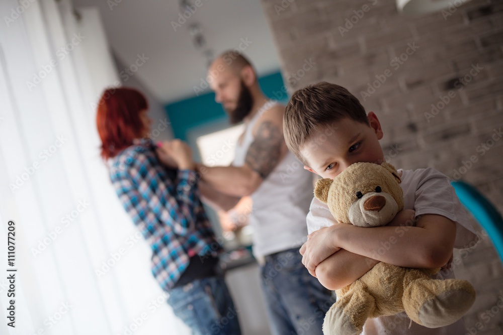 Sad, desperate little boy during parents quarrel