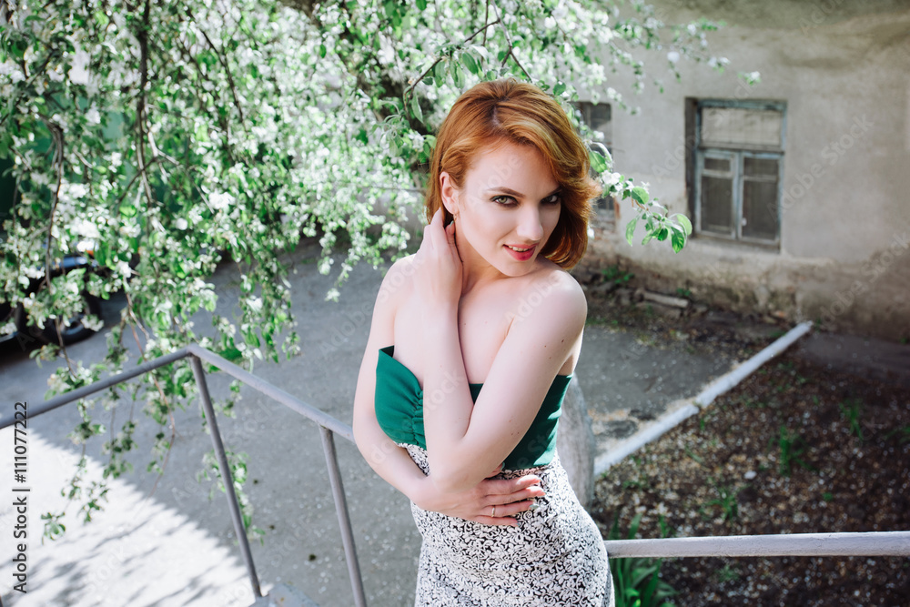 Naklejka premium Portrait of a beautiful woman with red hair on the nature