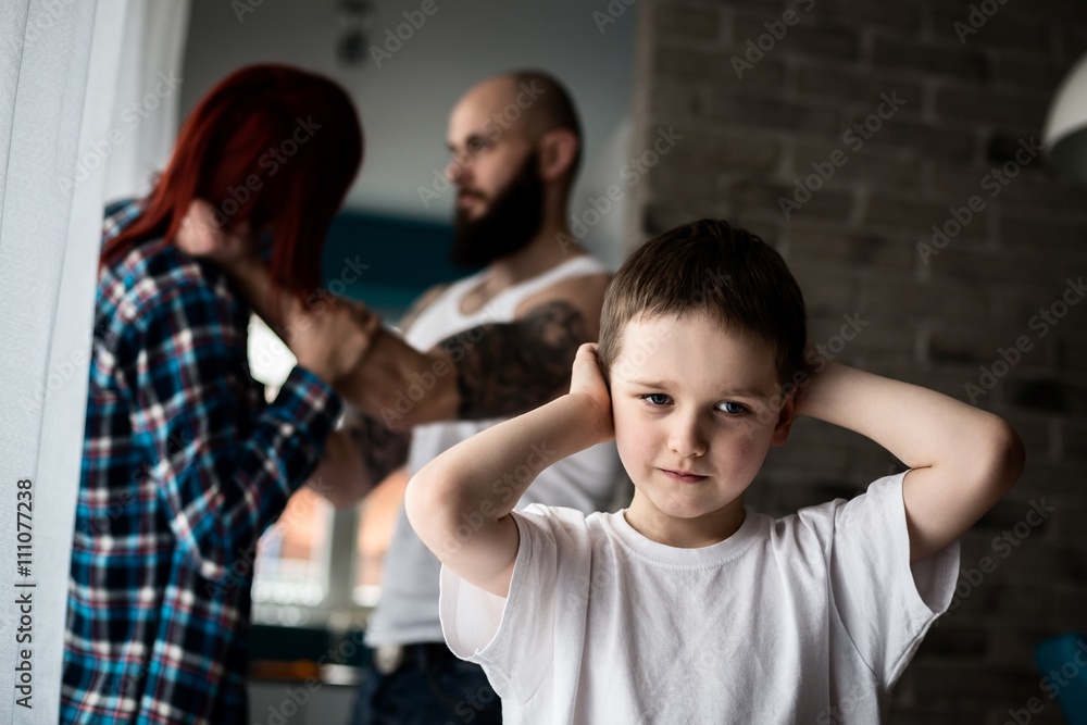 Sad, desperate little boy during parents quarrel