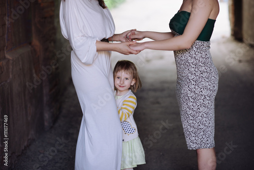 Two women holding hands with a child