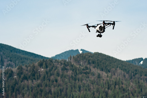 flying drone with camera/Drone with camera hovering over mountains