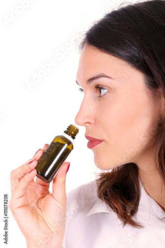 Female nurse smelling medicine bottle in the hand