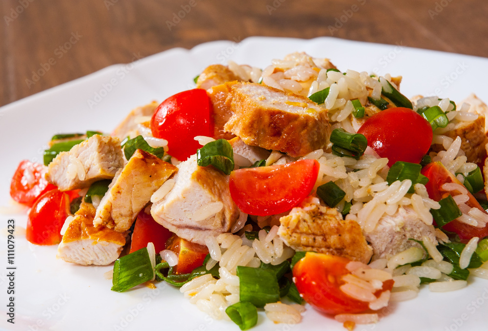 chicken and rice salad with fresh tomatoes in a plate on wooden table chicken and rice salad with fresh tomatoes in a plate on wooden table