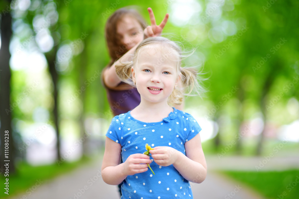 Two adorable little sisters laughing and hugging each other Two adorable little sisters laughing and hugging each other