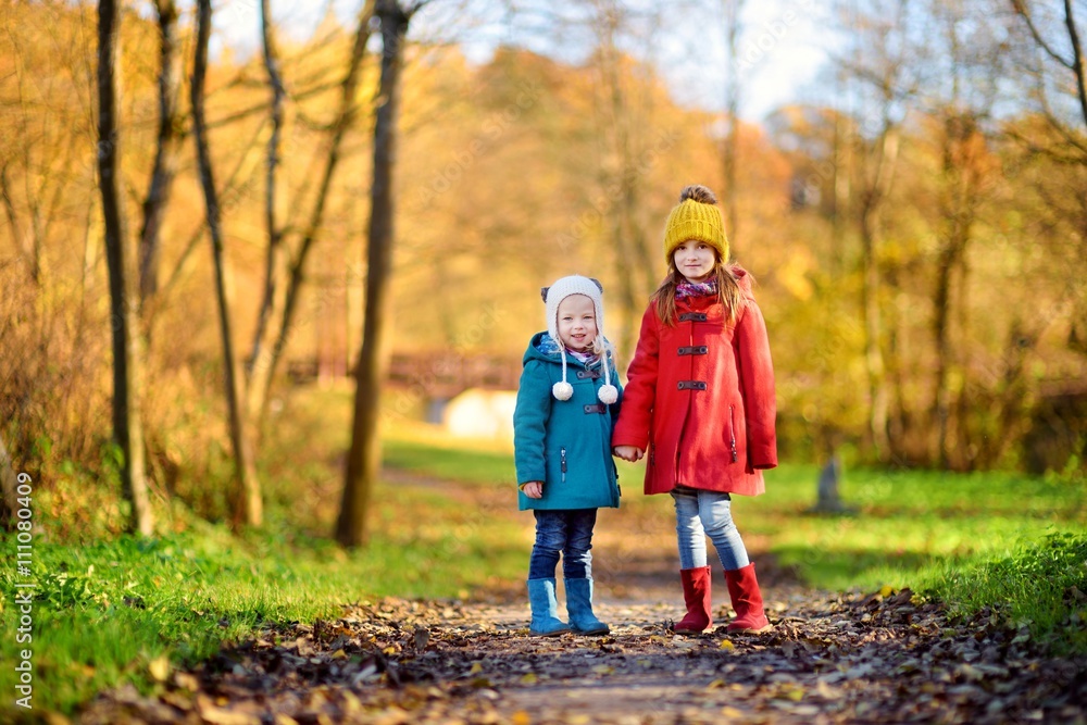 Two little sisters having fun together in beautiful autumn park Two little sisters having fun together in beautiful autumn park