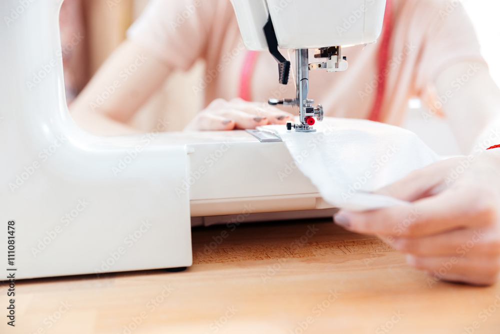 Woman seamstress sews clothes and put thread in needle