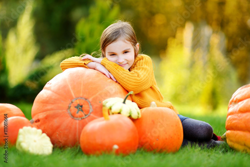 Adorable little girl having fun together on a pumpkin patch