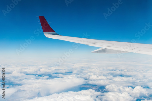 wings of airplane in the sky with cloud in sunny day