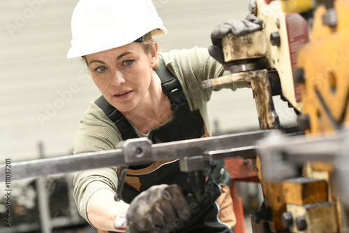 Woman with helmet working in metallurgy factory