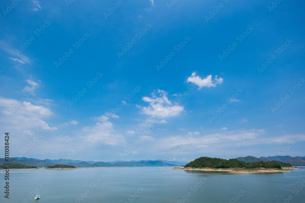 Blue sky with lake and mountain in background