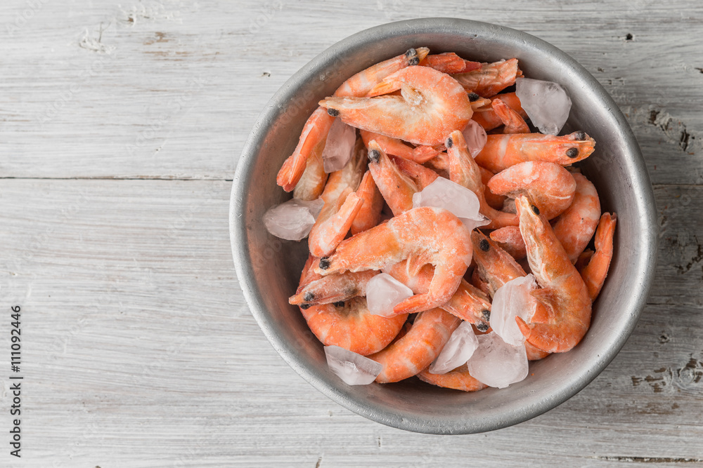 Shrimp and ice in the aluminum bowl on white boards Shrimp and ice in the aluminum bowl on white boards