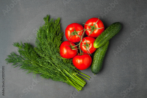 Tomatoes, cucumbers and green dill on a dark background. food concept. top view