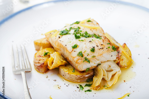 Roasted cod, codfish with baked potatoes and artichokes with lemon and herbs sauce