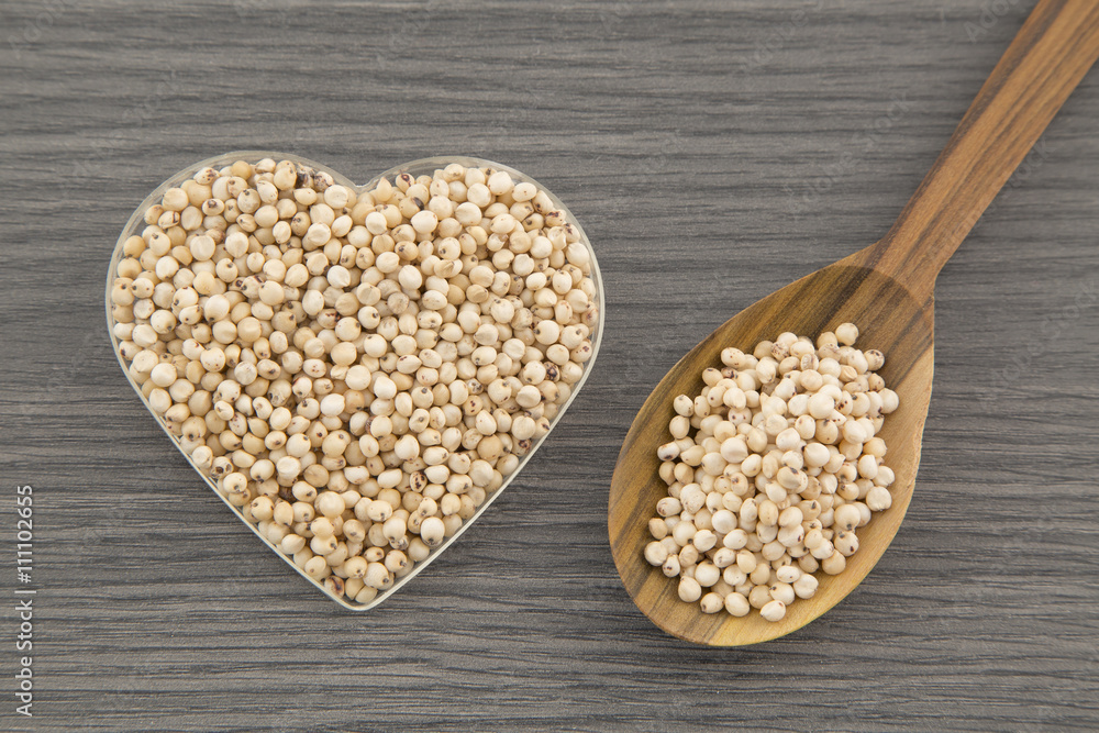 Millo cereal seeds on wooden table Millo cereal seeds on wooden table