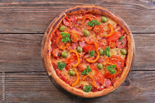 Tasty pizza with sausage and vegetables on wooden table background