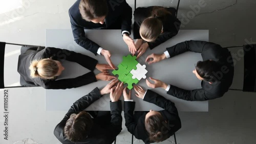 Group of business people assembling jigsaw puzzle and represent team support and help concept