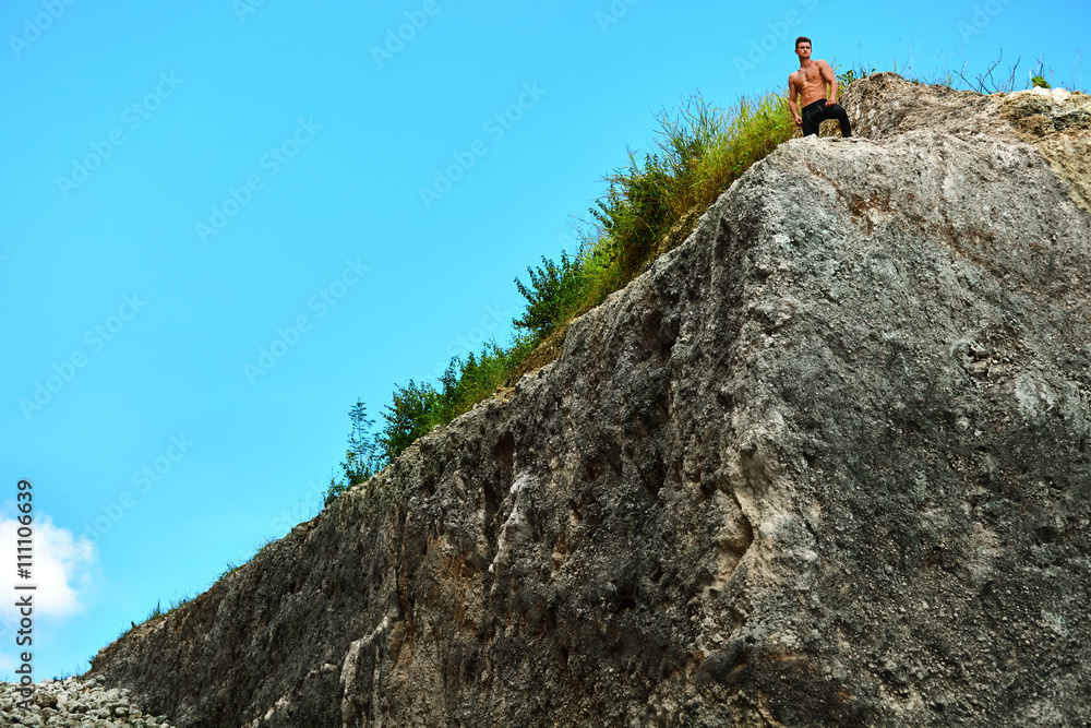 Fitness Male Hiker Standing On Top Of High Rocky Hill On Hot Sunny Summer Day. Topless Healthy Athletic Man With Muscular Body In Sportswear Enjoying View After Climbing Up. Outdoor Sport Concept