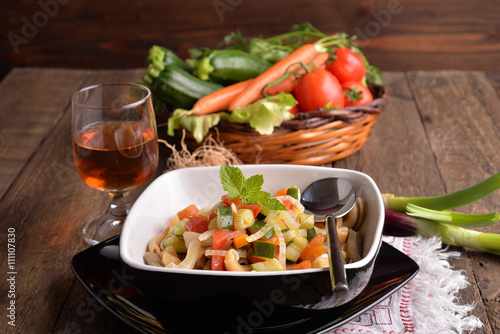 Pasta dish with black background and fresh vegetables