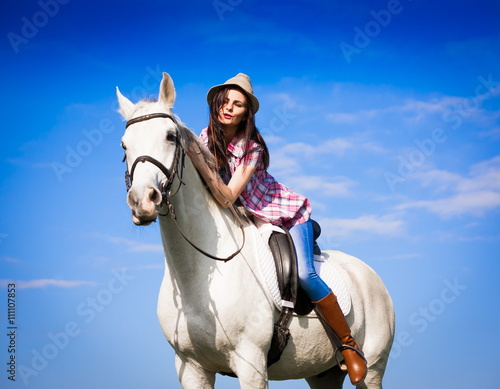 Woman sitting  horse. Day. Half height. Pink plaid shirt © erainbow