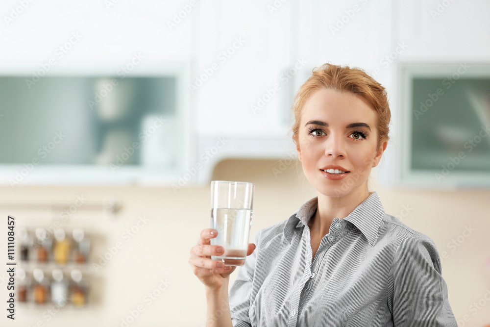 Young woman in the kitchen drinking water Young woman in the kitchen drinking water