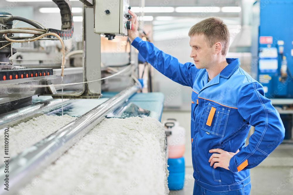 Laundry worker in the process of working on automated equipment carpets Laundry worker in the process of working on automated equipment carpets