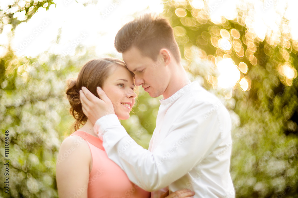 Couple in love under blooming branches spring day.