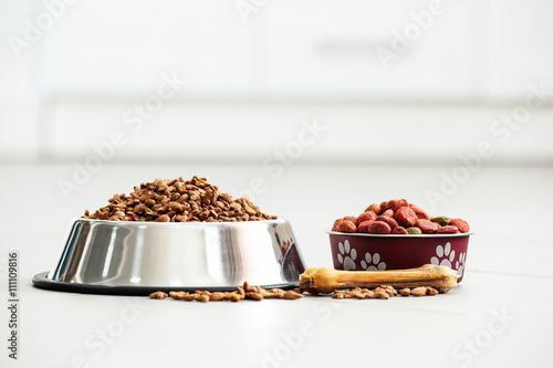 Fototapeta Naklejka Na Ścianę i Meble -  Pet food in metal bowls on a floor.