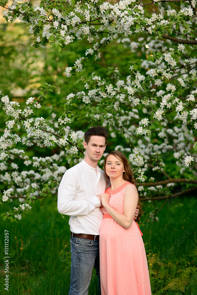 Couple in love under blooming branches spring day.