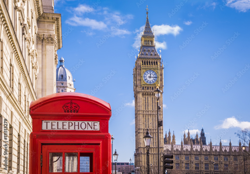 Traditional red british telephone box and Big Ben at Parliament Square with blue sky and clouds - London, UK