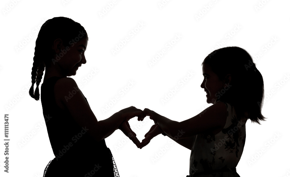 Silhouette of two girls making heart