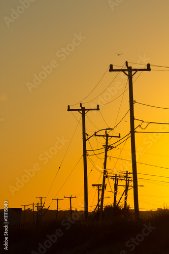 Electricity pylons and lines at sunset