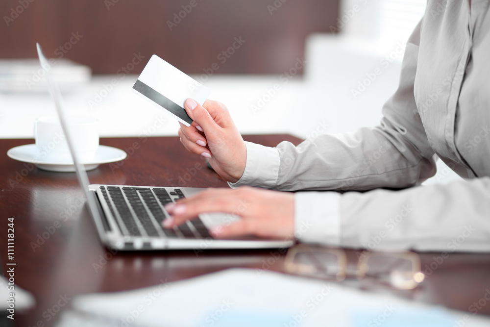 Close up of business woman hands using credit card and laptop computer Close up of business woman hands using credit card and laptop computer
