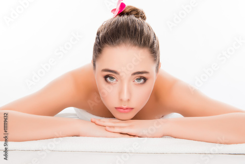 Beautiful calm young woman lying in spa salon and relaxing