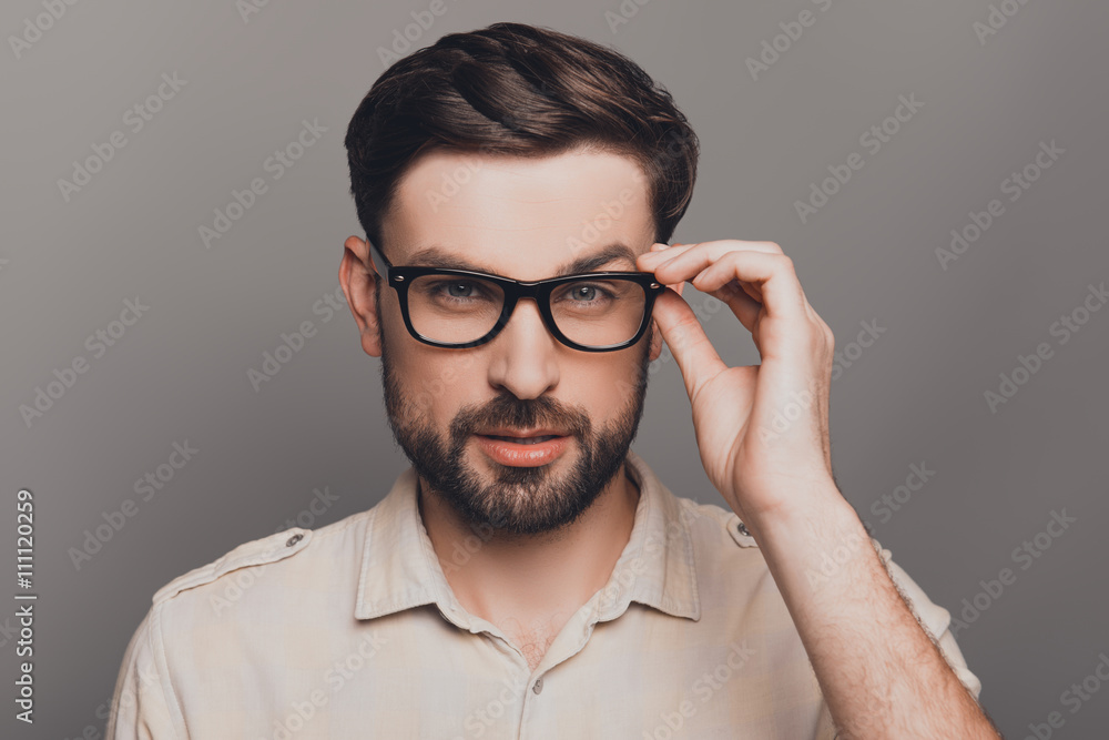 Portrait of smart handsome bearded man touching his glasses Portrait of smart handsome bearded man touching his glasses