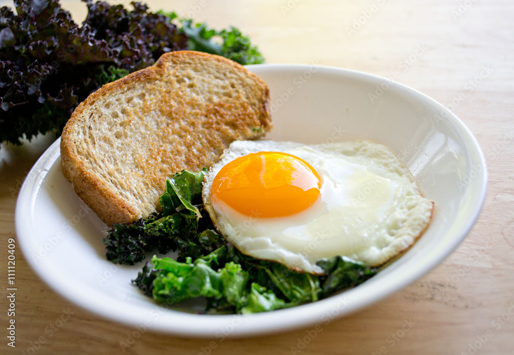 Local kale and a beautiful sunny side egg for a quick and easy weekday breakfast. Local kale and a beautiful sunny side egg for a quick and easy weekday breakfast.