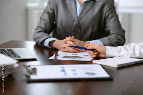 Close up of unknown business people at meeting discussing financial results