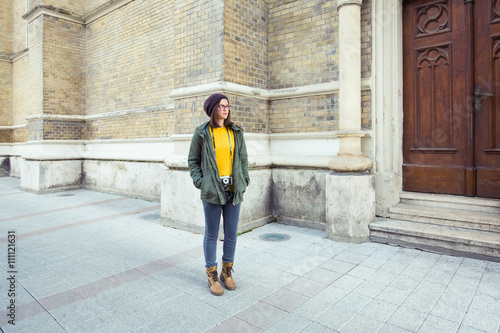 Young hipster woman walking on the street of an old European town
