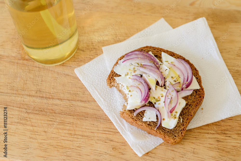 toast with onion feta oregano on a wooden cutting board with apple juice in the bank toast with onion feta oregano on a wooden cutting board with apple juice in the bank